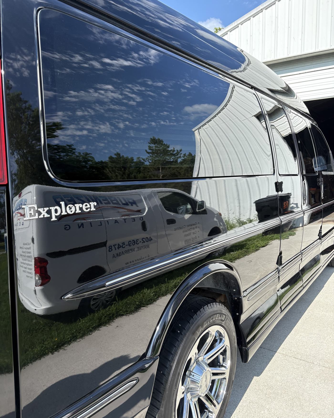 A freshly detailed black van with a deep mirror-gloss finish